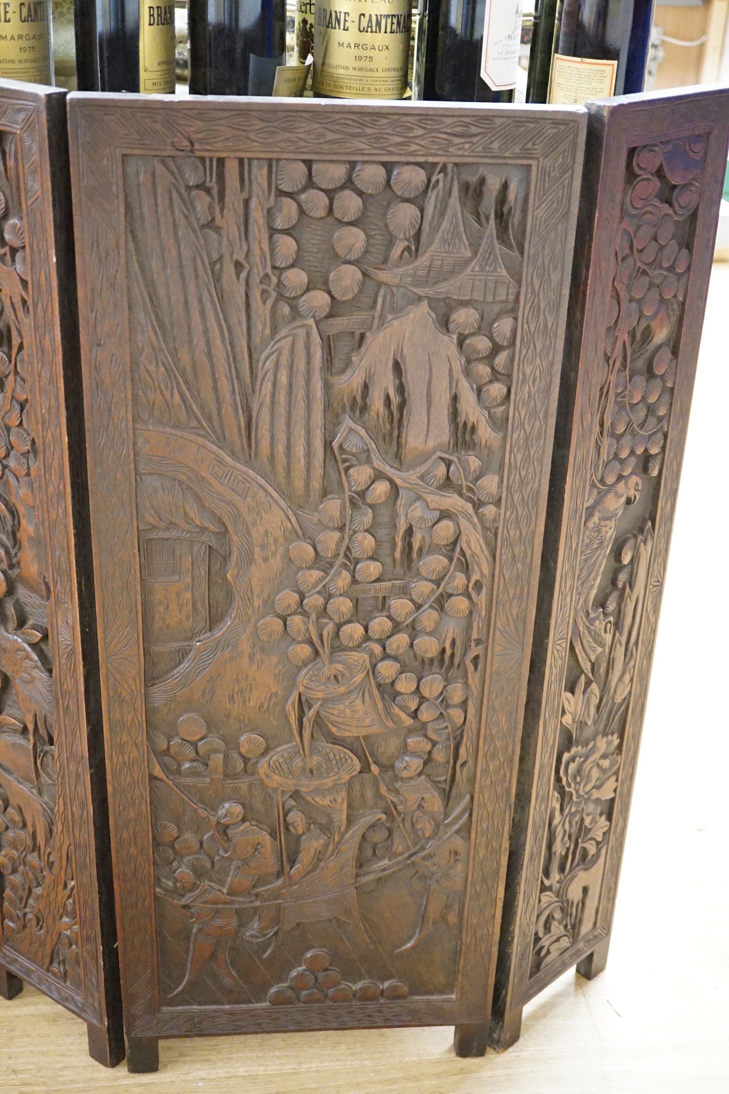 An Oriental three panelled carved wood folding screen, 84cm tall